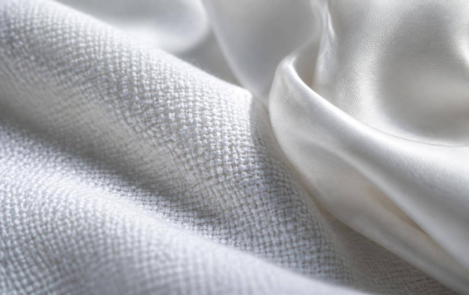 Close-up of crisp cotton weave beside a soft silk fold